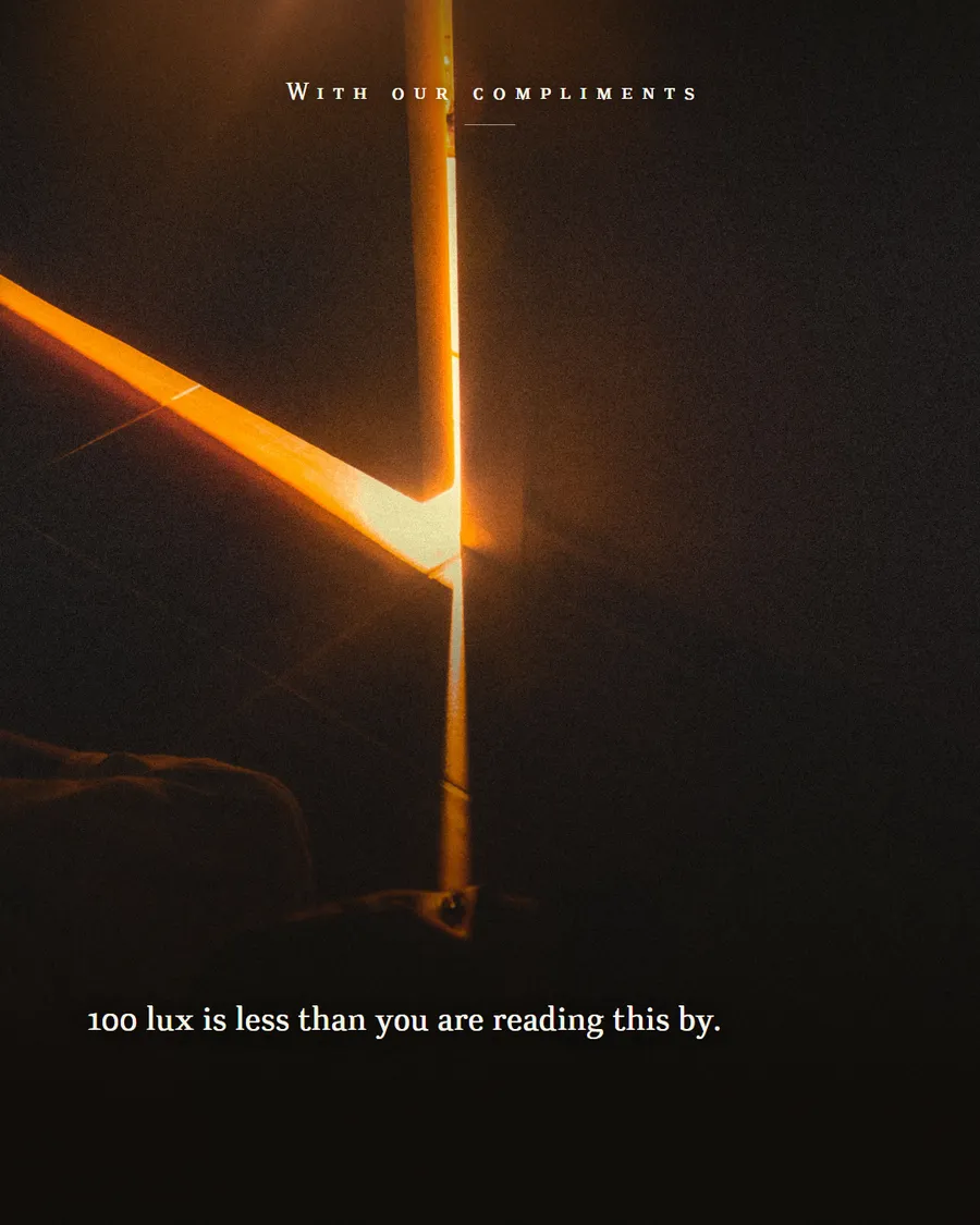 A blade of orange light spilling under and around a bedroom door in a dark room