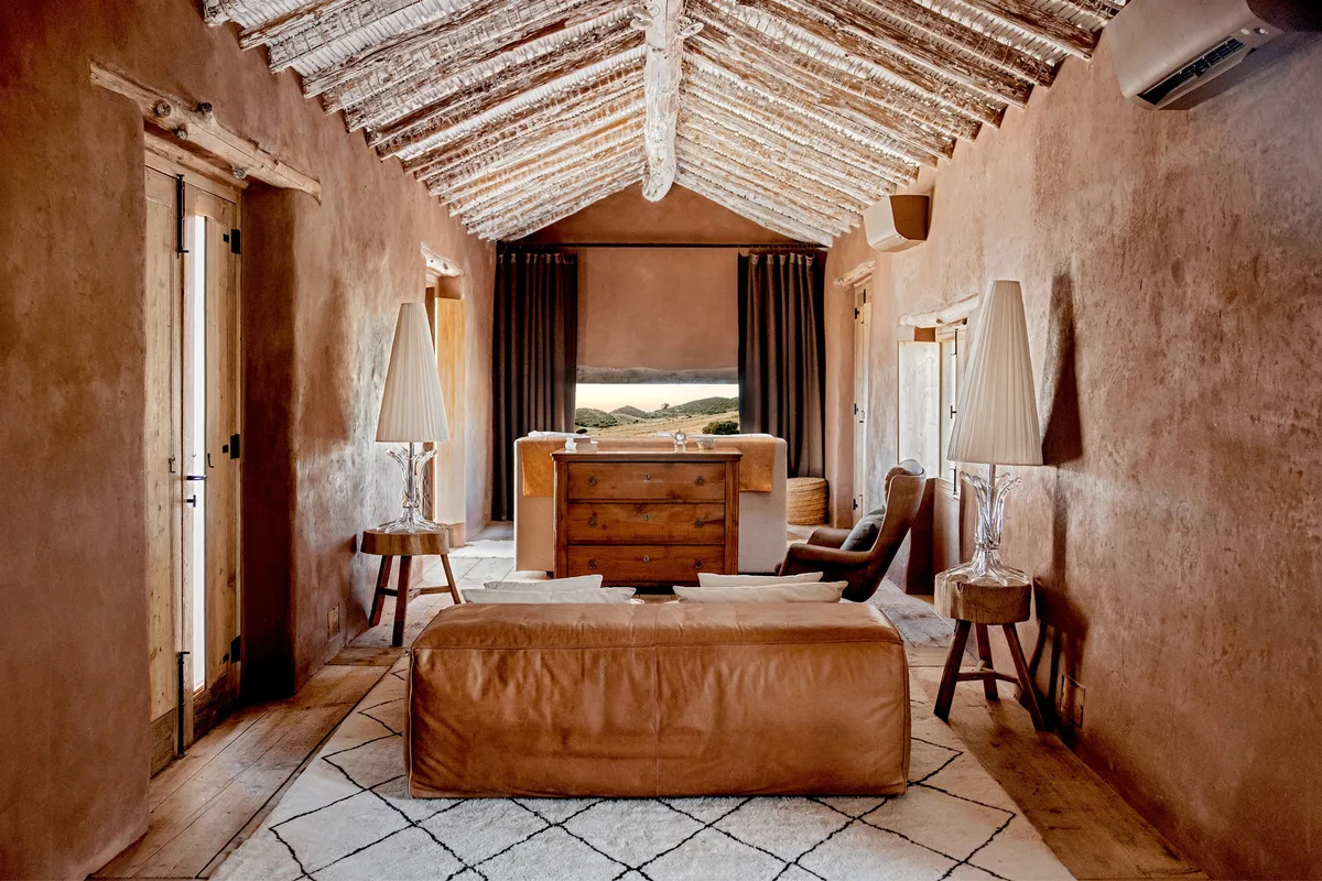 The Priam suite at La Donaira, with adobe walls, original beams and a view across the estate