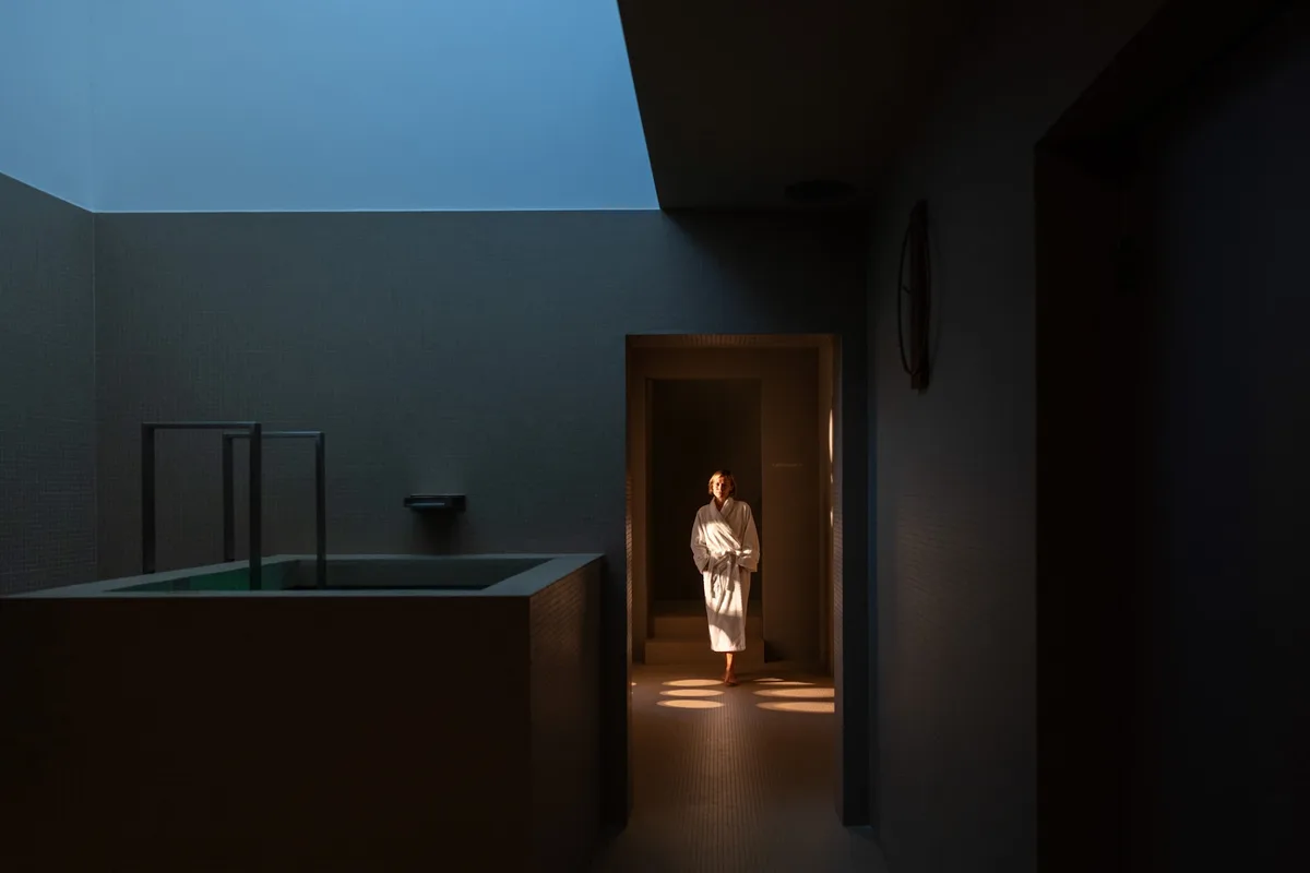 A guest in a white robe beside the indoor pool at Waldhaus Sils