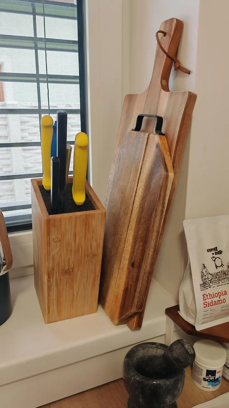 Wooden cutting boards and a stone mortar by the window